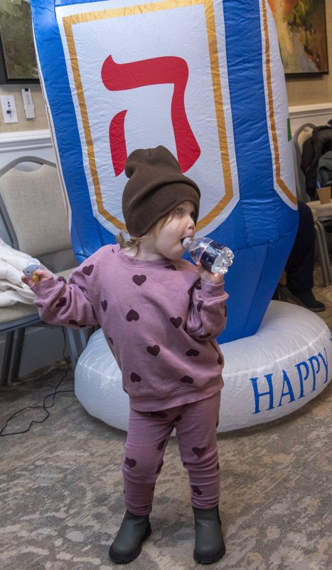Zeesa Vogel dances to the music near the large dreidel.